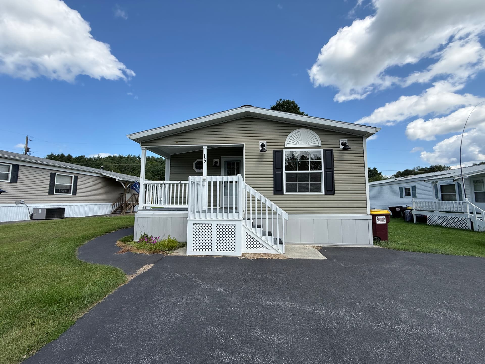 15 Kevin Lane — a single-story home with a wooden deck and level lawn