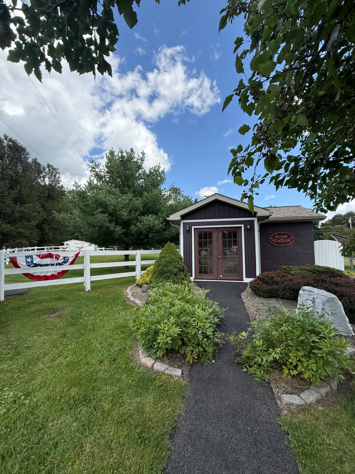 A covered mail pavilion with cedar posts on a quiet community lane