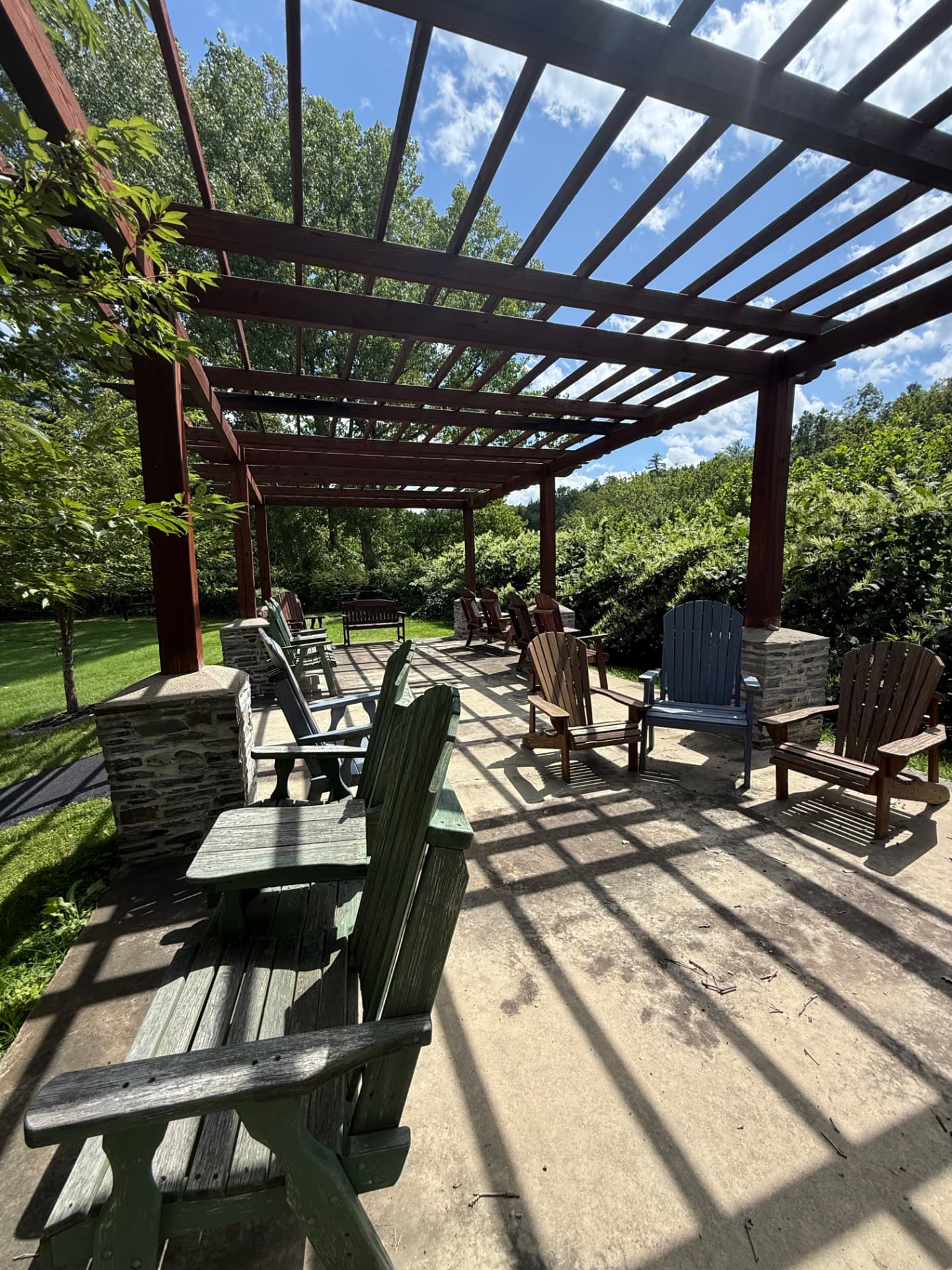 Adirondack chairs beneath the community pergola on the open lawn